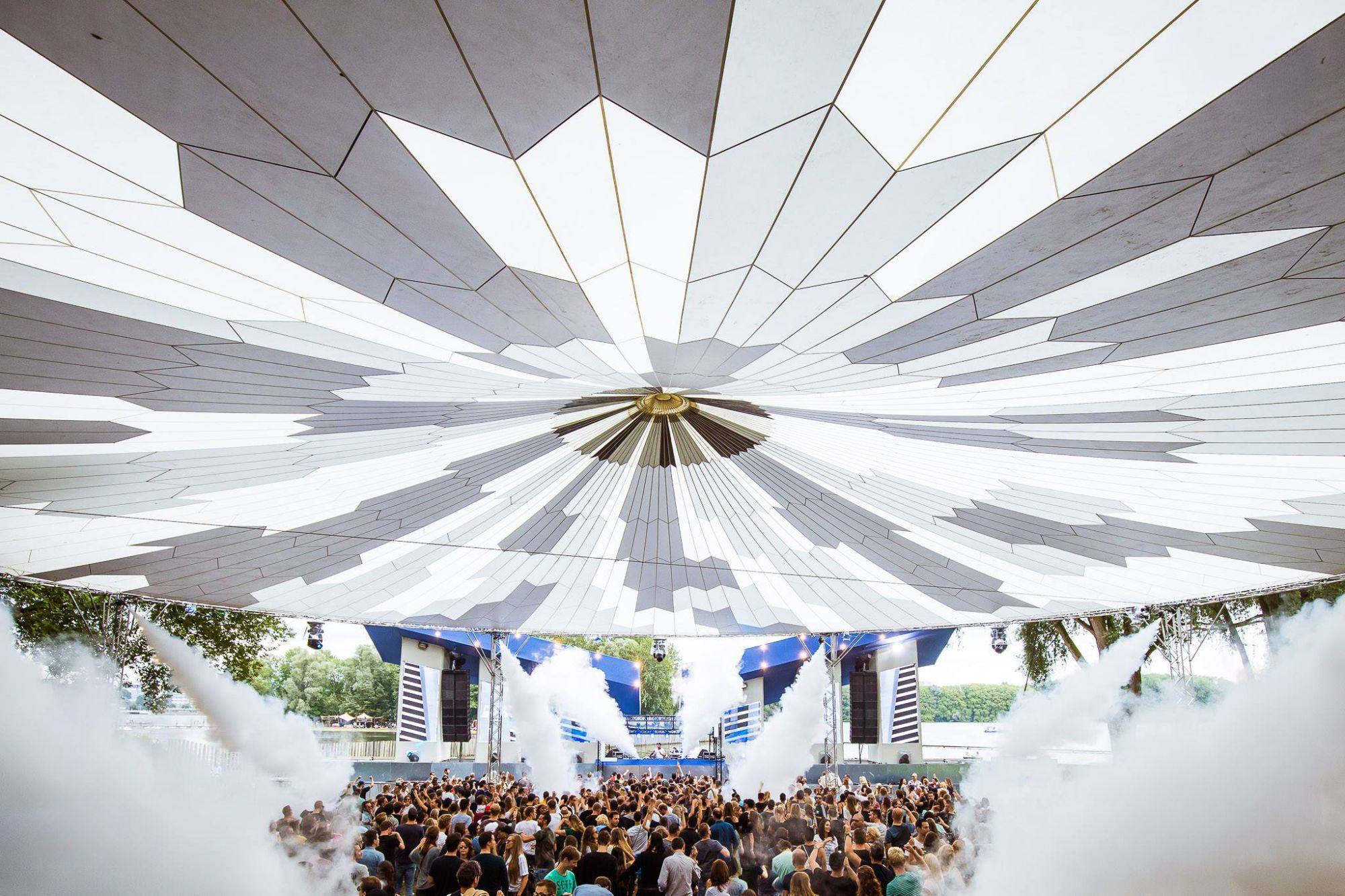 Perfect Sky-overkapping met wit doek boven een festivalpubliek